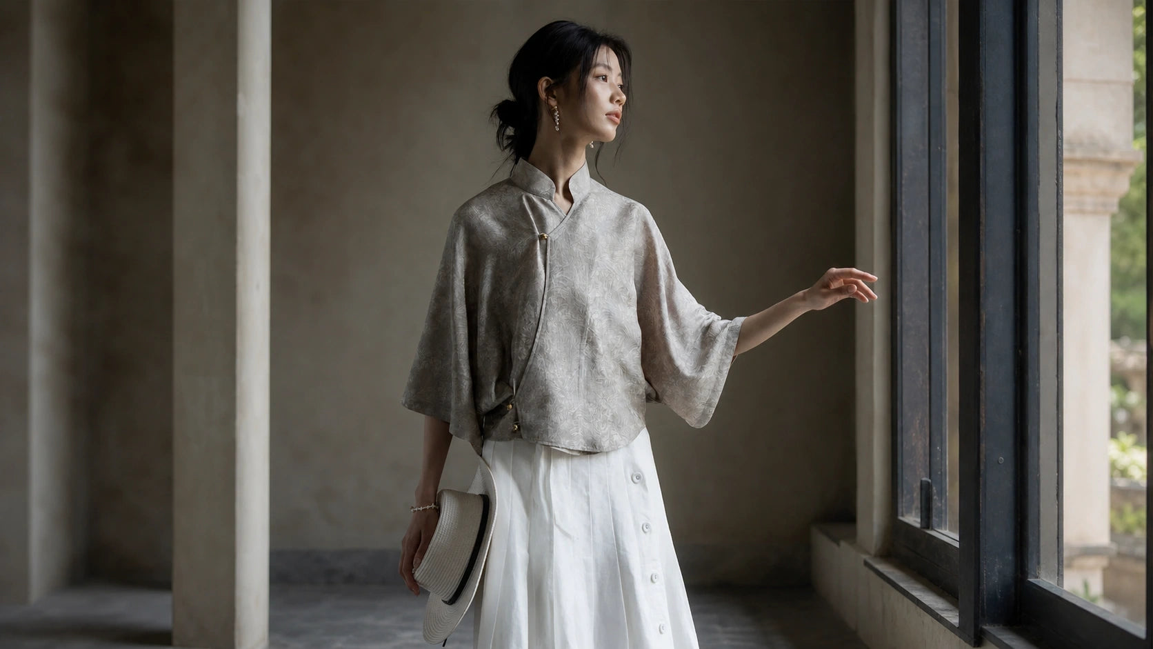 Cheongsam-inspired silk top styled casually with a white skirt and straw hat