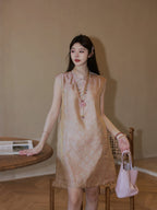 Model wearing the pink jacquard mulberry silk dress with a Mandarin collar, paired with a pearl necklace and a pink bag, showcasing a side profile.