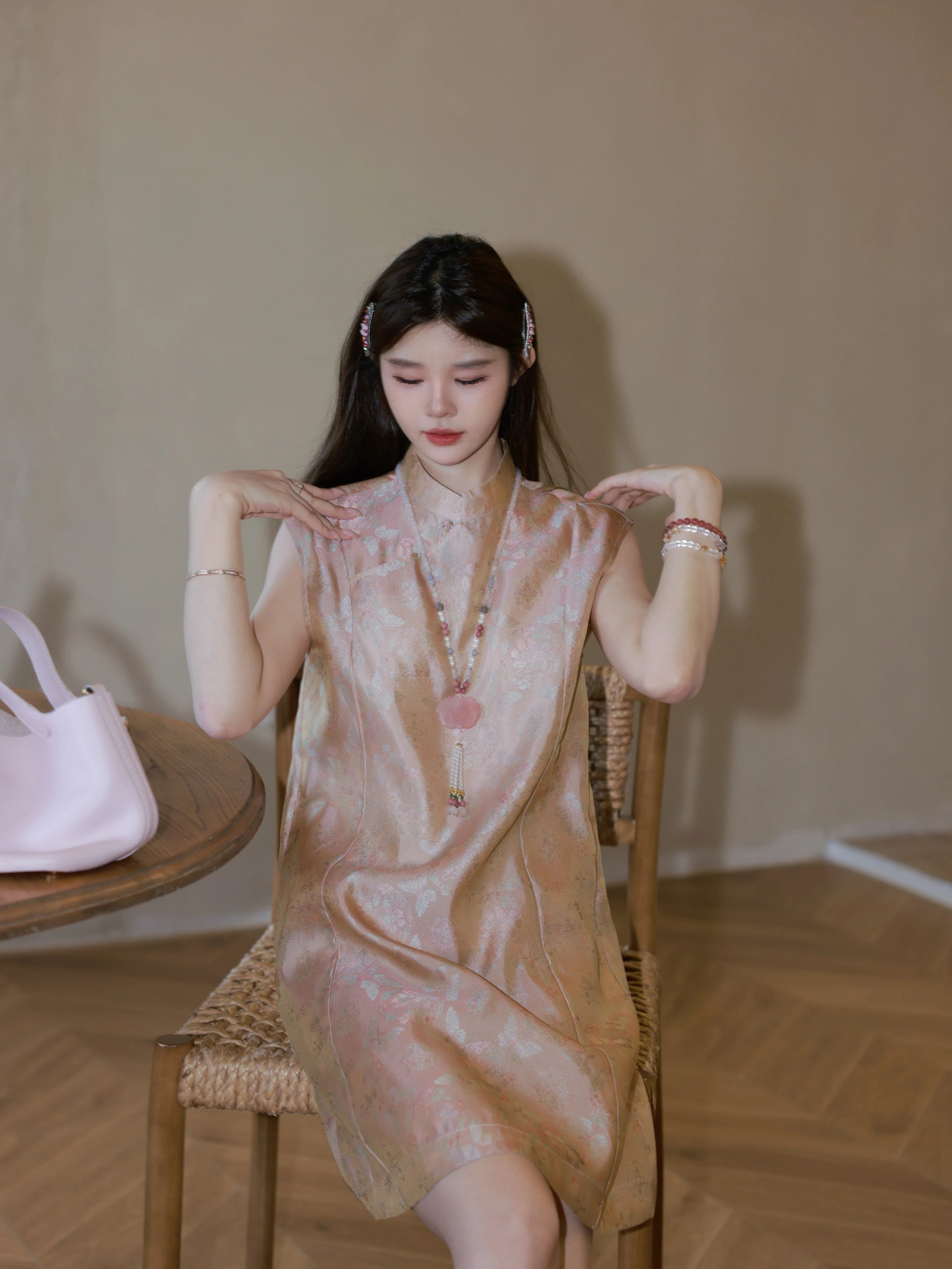 Sitting view highlighting the silky sheen of the mulberry silk fabric and the delicate butterfly jacquard pattern, featuring a sleeveless design.