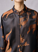 Close-up of the Mandarin collar and traditional loop-and-bead buttons on the bronze jacket