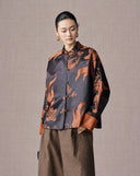 Three-quarter view of the antique bronze silk-blend jacket showing its relaxed straight fit