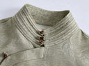 Close-up of the stitched stand collar, three brown buttons and asymmetric neckline panel on an antique sage jacquard shirt.