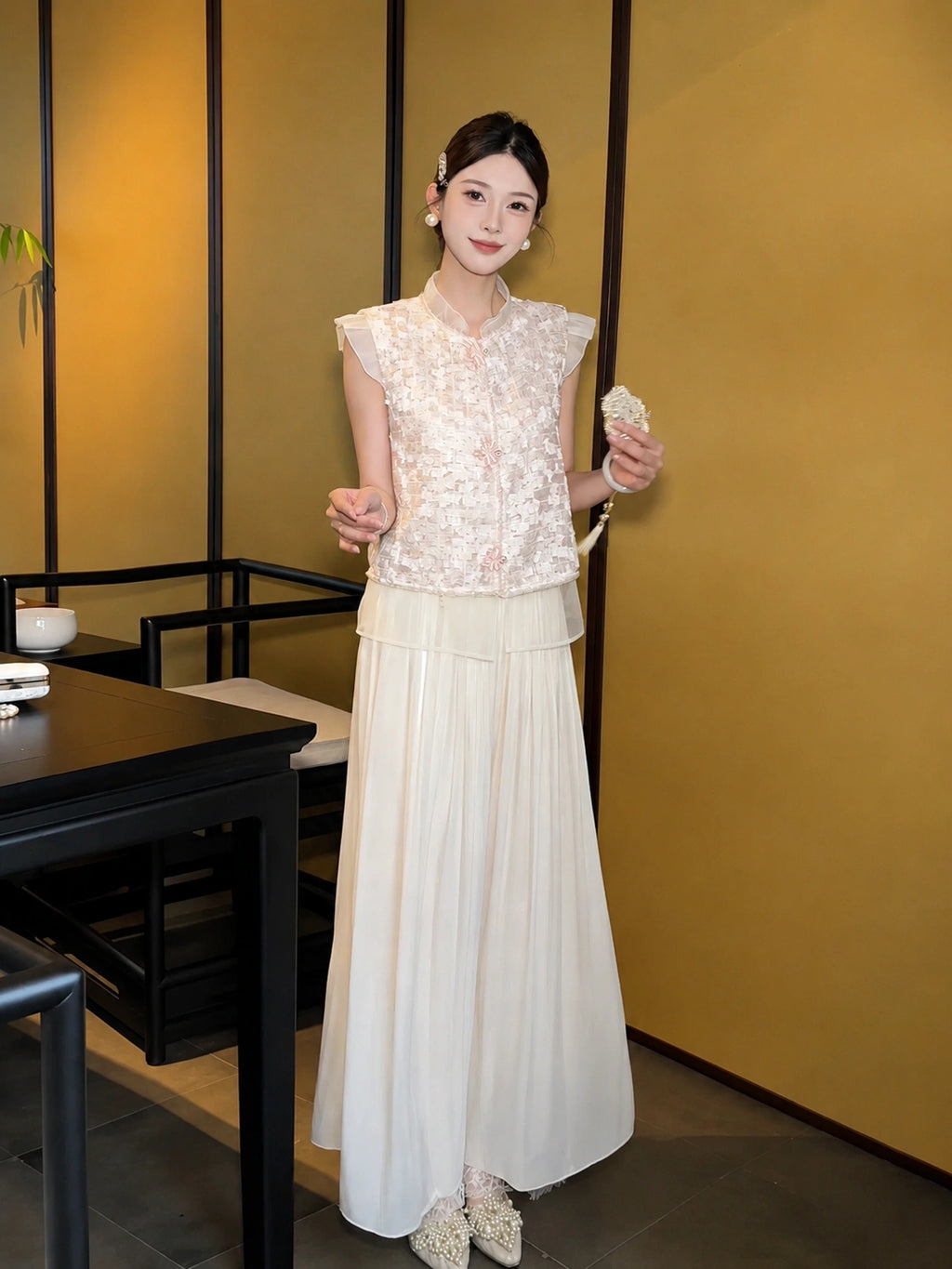 Model wearing apricot cream pleated wide-leg pants with a layered lace hem, paired with a lace top and pearl shoes, showcasing the elegant drape of the 100% polyester fabric.