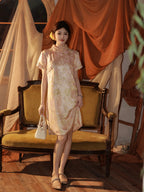 Full view of a model wearing an apricot silk dress with a stand collar and short sleeves