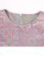 Close-up of a dusty rose Song brocade silk dress showing the round neckline and woven Badayun motif