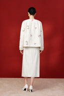 Back view of the beige jacket on a model, with butterfly embroidery across the back and sleeves.