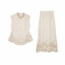 Flat lay of a beige Cheongsam set featuring a sleeveless vest with lace peplum and a matching midi skirt with a scalloped lace hem.