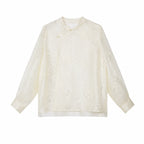 Flat lay of a beige long-sleeve Cheongsam blouse with a mandarin collar, floral embroidery, and sequin details, crafted from 100% polyamide.