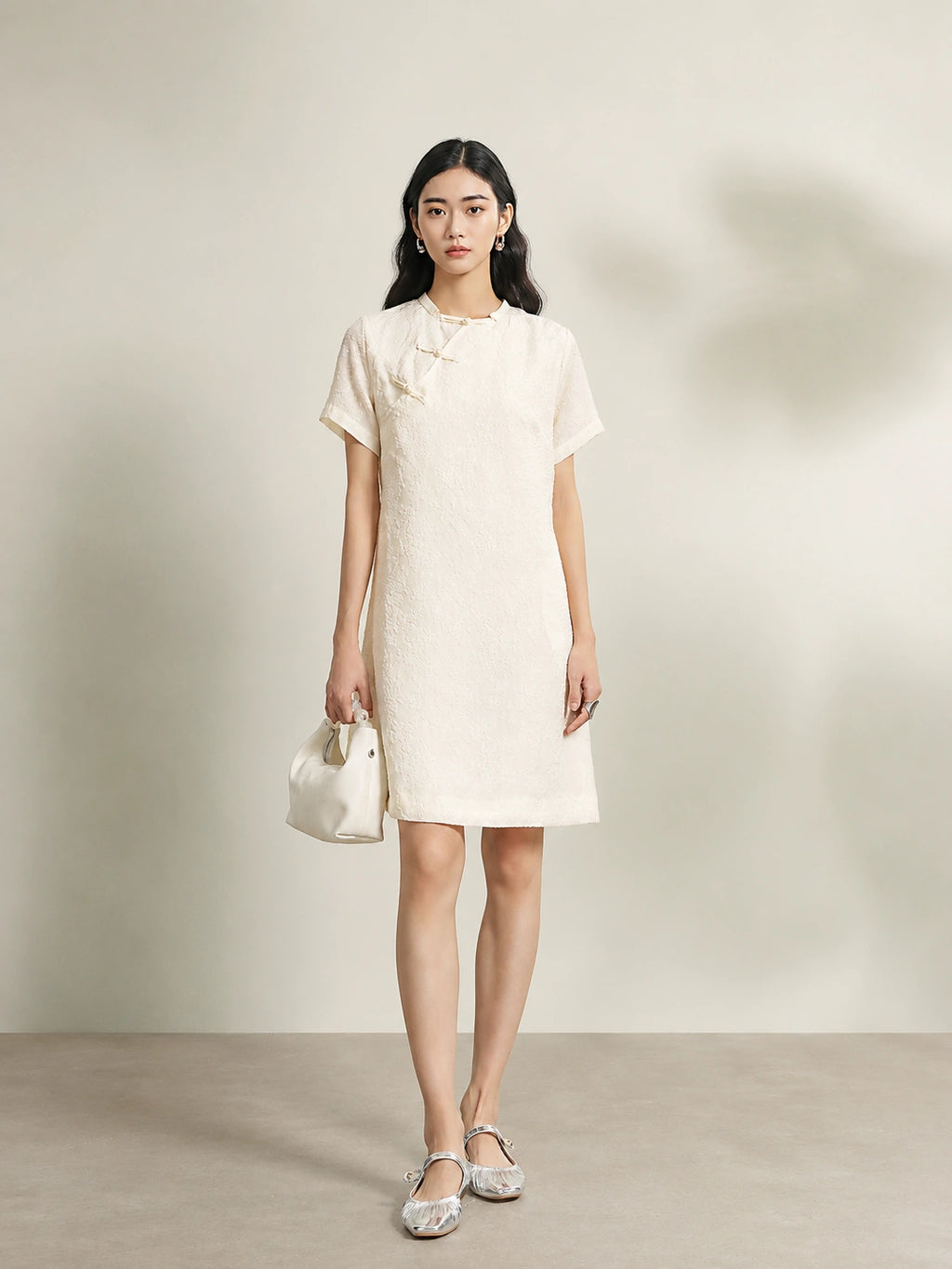 Model wearing an beige 100% mulberry silk floral shift dress with a relaxed silhouette.