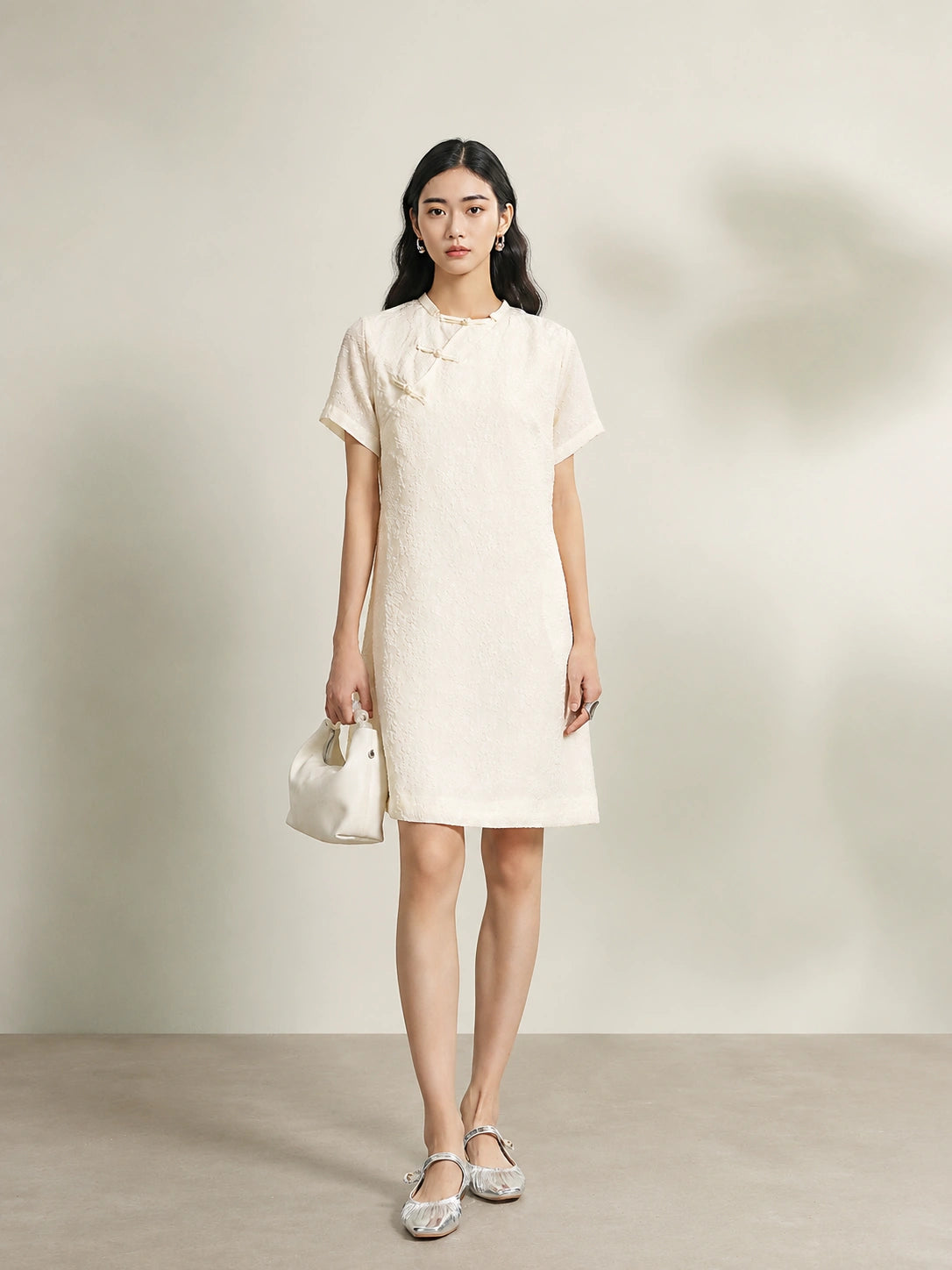 Model wearing an beige 100% mulberry silk floral shift dress with a relaxed silhouette.