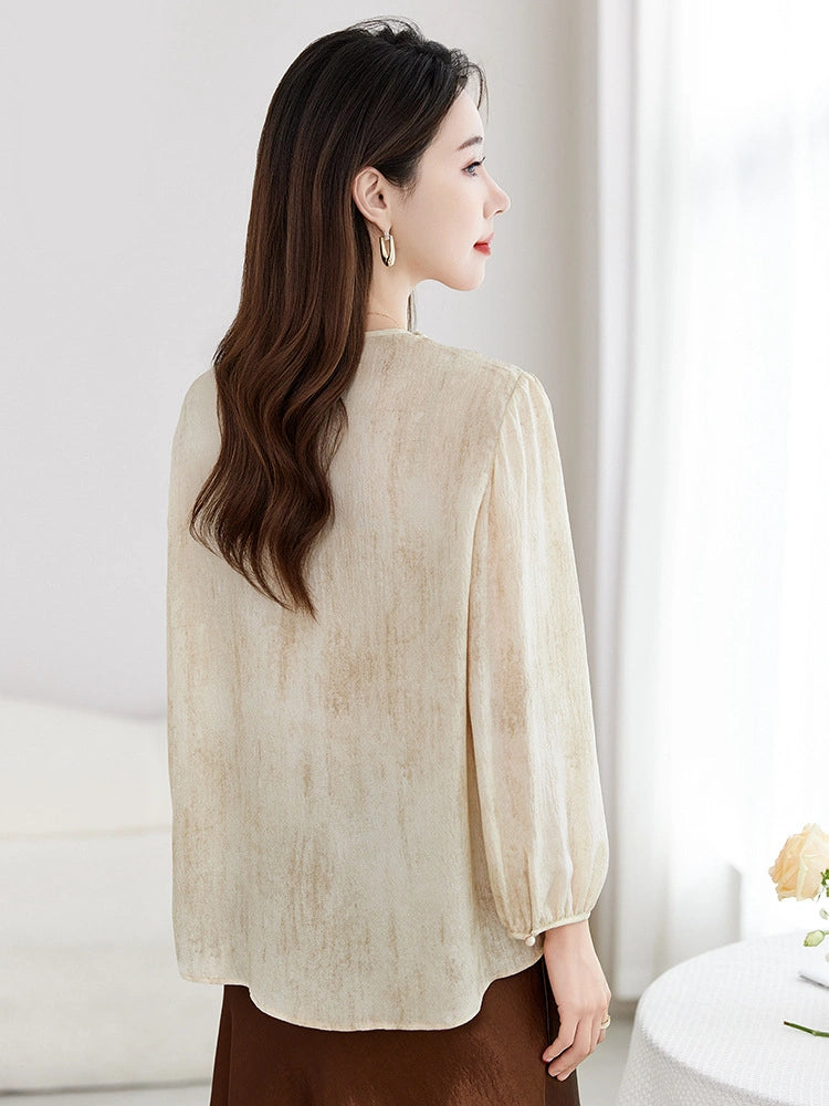 Back view of a beige 100% mulberry silk blouse with a relaxed fit and gathered details at the waist, highlighting the elegant drape.