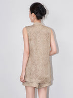 Back view of a model wearing the beige sleeveless viscose vest and matching shorts set.