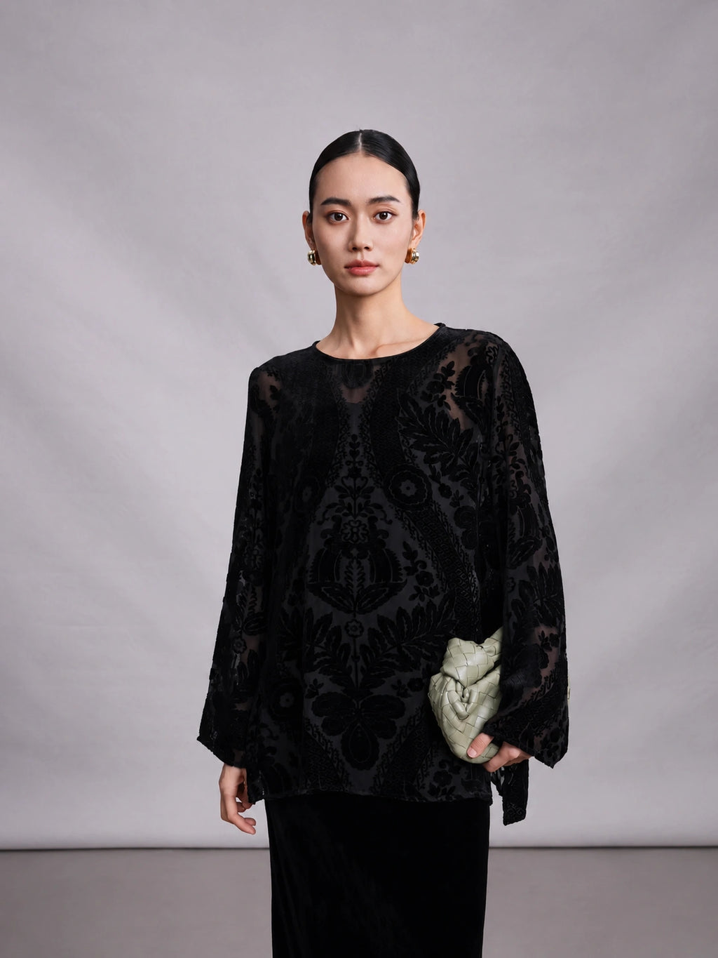 Close-up of black burnout mulberry silk blouse with sheer floral velvet pattern.