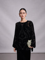 Close-up of black burnout mulberry silk blouse with sheer floral velvet pattern.