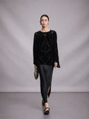 Model wearing a black mulberry silk burnout blouse in a walking pose.