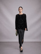 Model wearing a black mulberry silk burnout blouse in a walking pose.