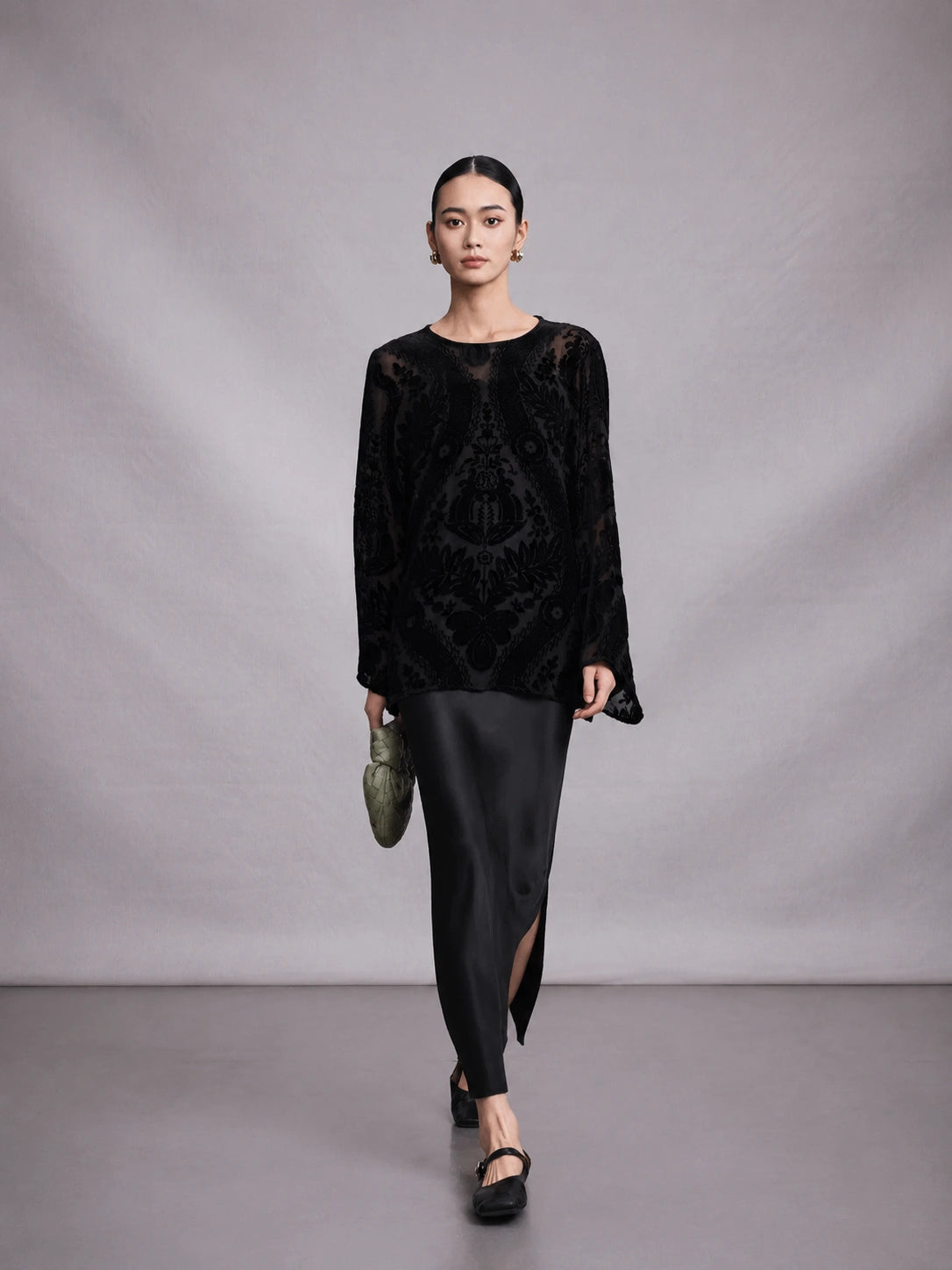 Model wearing a black mulberry silk burnout blouse in a walking pose.