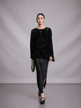 Model wearing a black mulberry silk burnout blouse in a walking pose.
