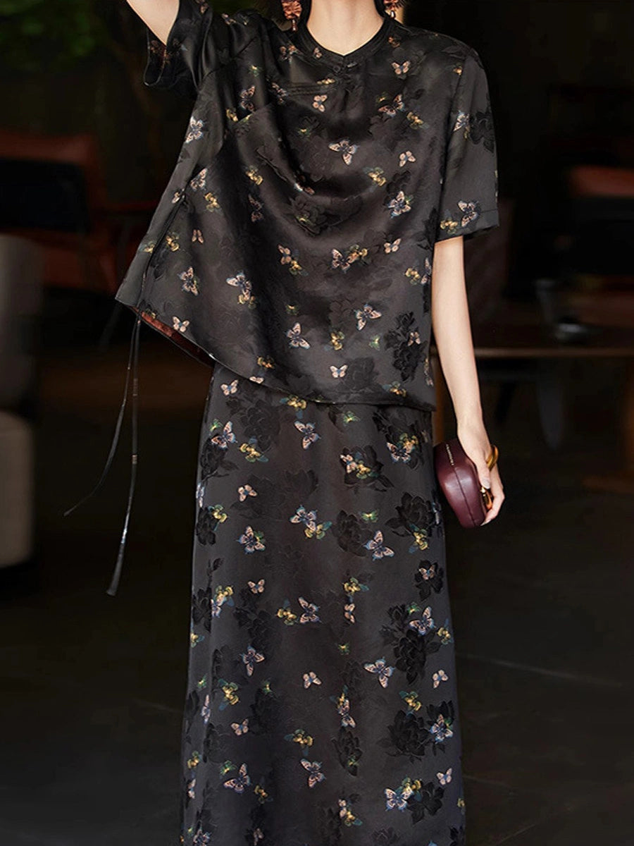 Woman wearing a black butterfly-print Xiangyunsha silk top with a matching long skirt