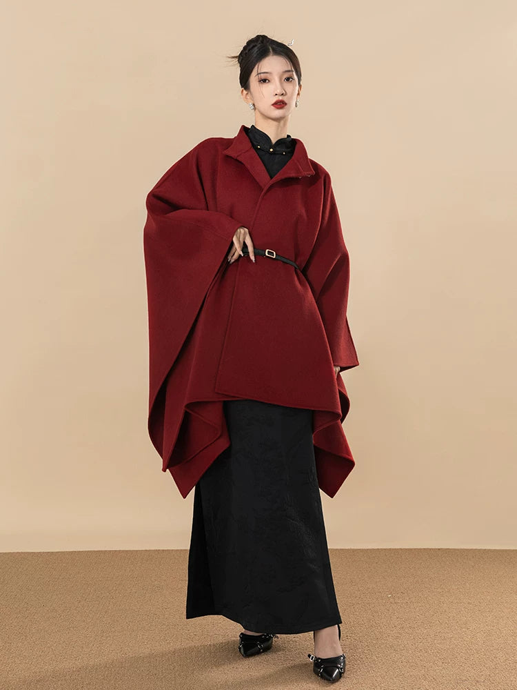 Black jacquard cheongsam styled with a burgundy cape for elegant autumn layering.