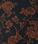 Close-up of the copper botanical floral jacquard pattern and black frog-button closure