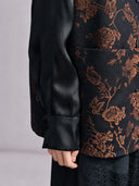 Close-up of the black satin sleeve layered beneath the copper floral jacquard vest