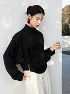 Side profile of the Black Cross-Over Mandarin Collar Blouse with decorative button details.
