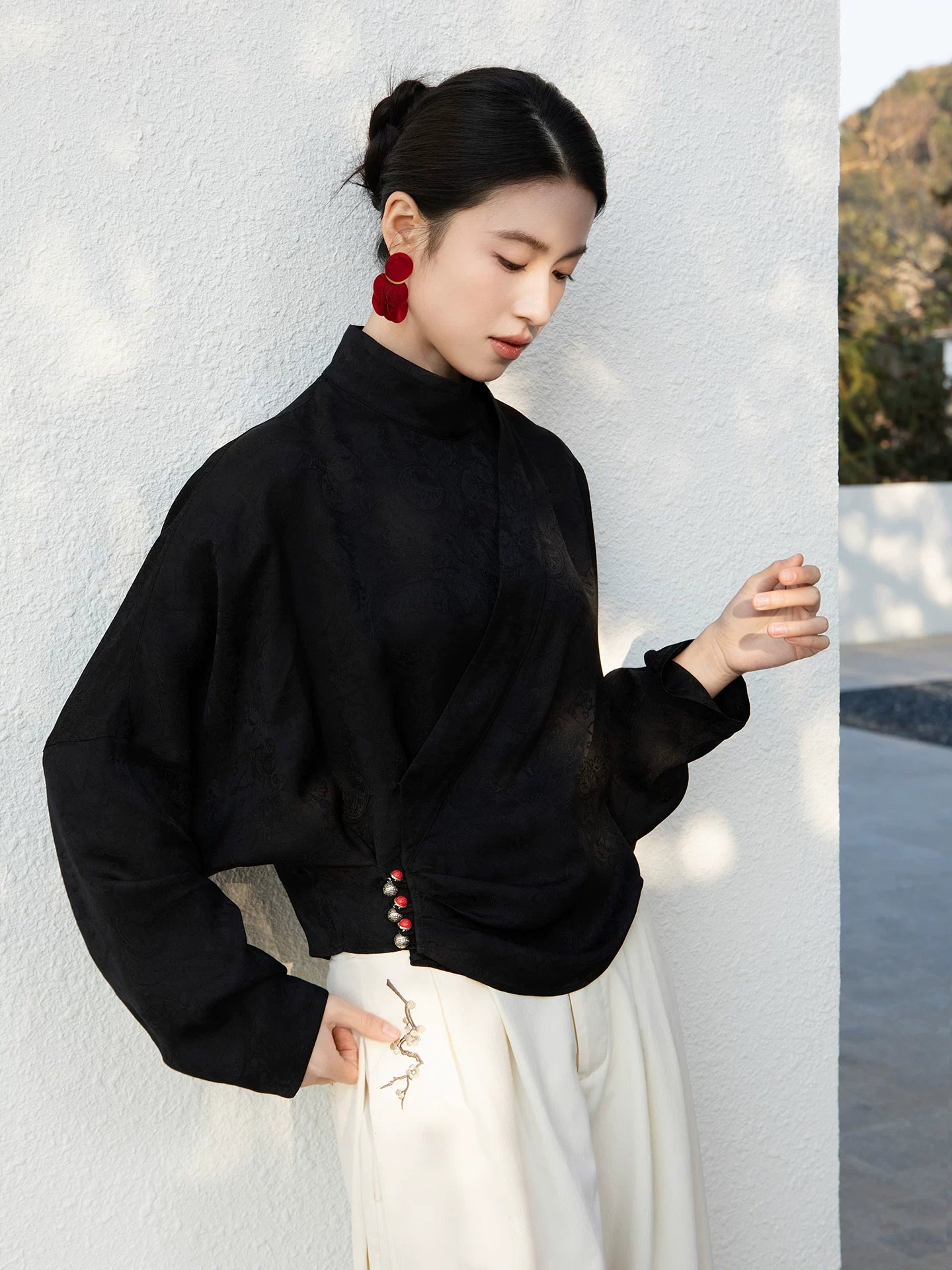 Side profile of the Black Cross-Over Mandarin Collar Blouse with decorative button details.