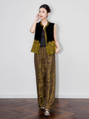 Model wearing a black Chinese-style velvet vest with gold floral jacquard panels and a softly flared hem.