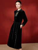 Angled model view of the black midi dress with gold botanical embroidery