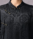 Close-up of the tonal jacquard pattern, Mandarin collar and gold-accented frog-button closures