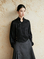 Black Mandarin collar wrap blouse styled with a charcoal pleated skirt.