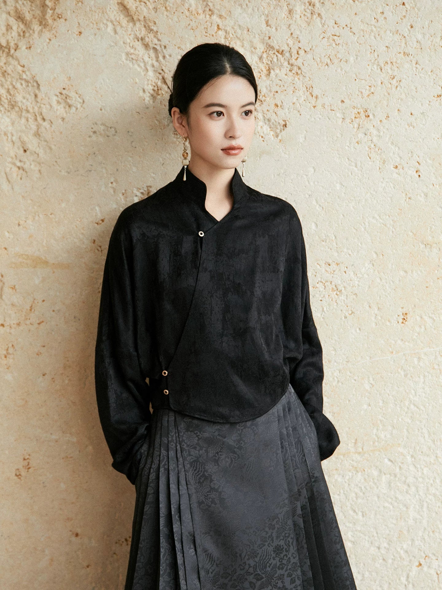 Black Mandarin collar wrap blouse styled with a charcoal pleated skirt.