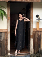 Woman wearing a black mulberry silk sleeveless maxi dress with star embroidery for summer elegance
