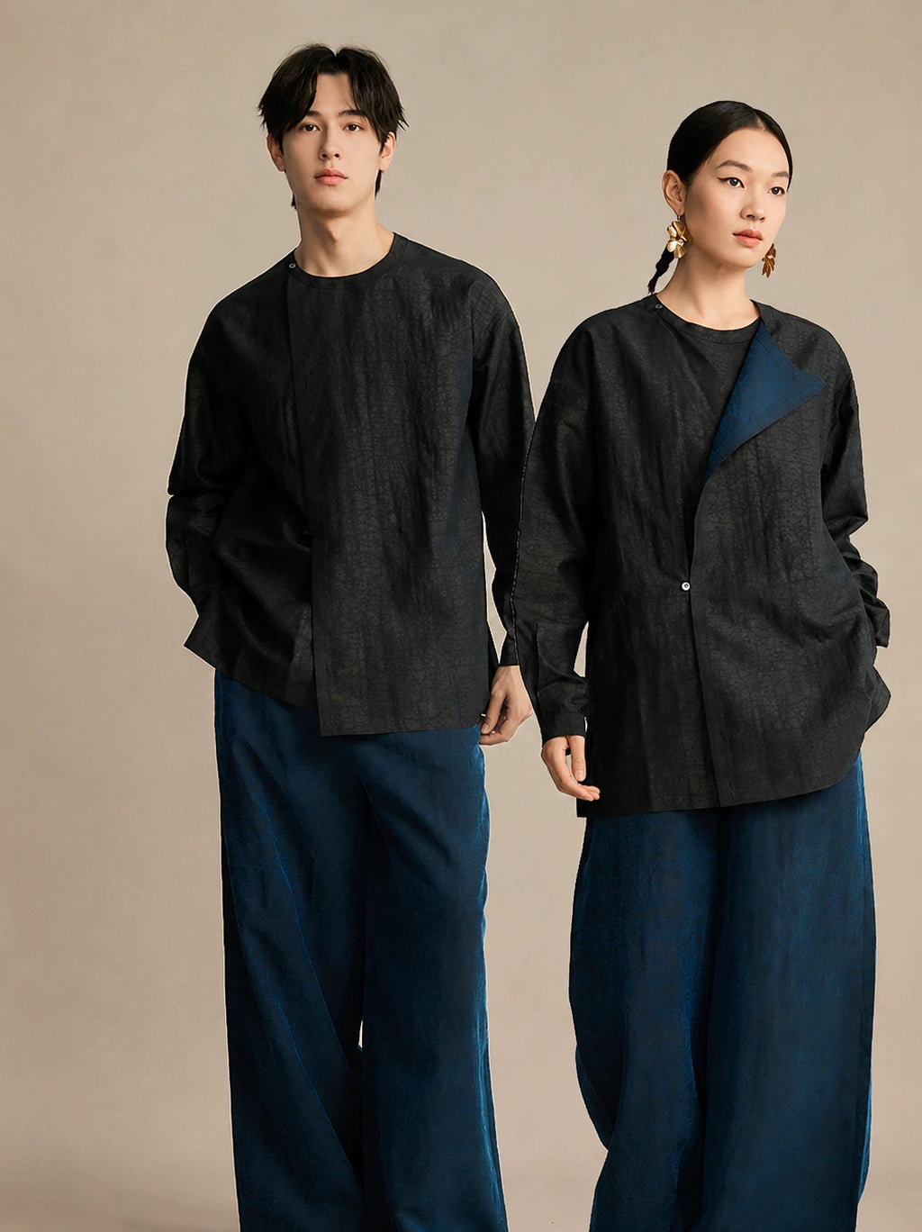 Black 100% mulberry silk unisex designer shirt styled on male and female models with a modern asymmetric collar.