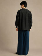 Back view of a relaxed-fit black mulberry silk unisex shirt with clean minimalist tailoring.