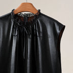 Close-up of the lace-trimmed neckline and self-tie detail on the black mulberry silk blouse