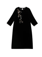 Flat lay of black mulberry silk midi dress featuring delicate floral branch embroidery.