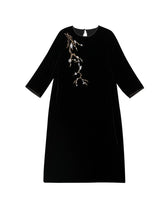 Flat lay of black mulberry silk midi dress featuring delicate floral branch embroidery.