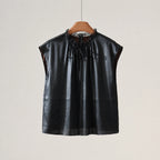 Front product view of a black silk cap-sleeve blouse with a lace-trimmed neckline and self-tie