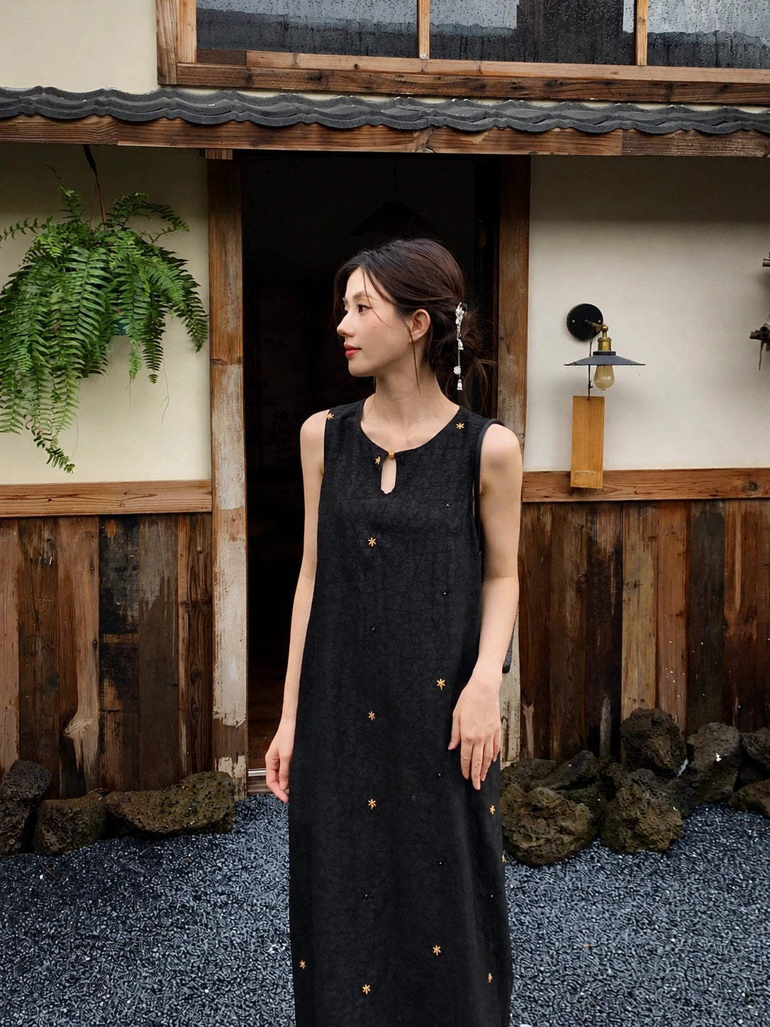 Side view of women's black silk long dress with relaxed fit and elegant sleeveless design