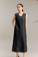 Full body shot of a black silk sleeveless V-neck dress with side pockets and A-line silhouette, crafted from 100% mulberry silk, featuring a midi length and side slits for easy movement.