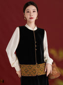 Model wearing the black velvet vest with an antique gold scroll-patterned hem and an ivory blouse.