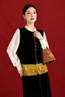 Model showing the buttoned black velvet vest with a rabbit-patterned hem and gold-toned buttons.