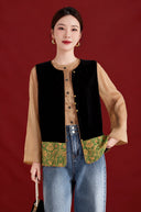 Model wearing the jade green floral-trimmed black velvet vest open over a tan blouse and jeans.