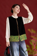 Front view of the green-trimmed black velvet vest, styled with an ivory blouse and jeans.