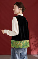 Back view of the black velvet vest with a mottled green patterned hem and tan edging.