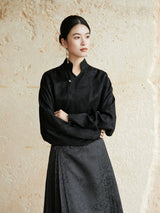 Minimalist black wrap blouse with Mandarin collar and long sleeves.