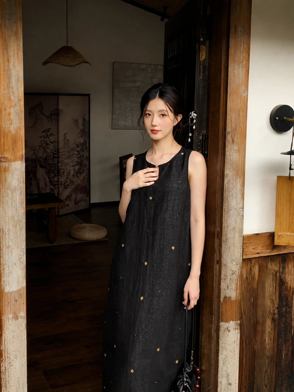 Close-up view of black Xiangyunsha silk dress featuring delicate star embroidery and traditional fabric texture