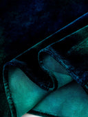 Close-up of the blue dress fabric showing its lustrous surface and reverse side